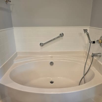 After: bathtub with a clean white tile surround