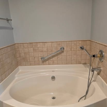 Before: bathtub with a dated tan tile surround
