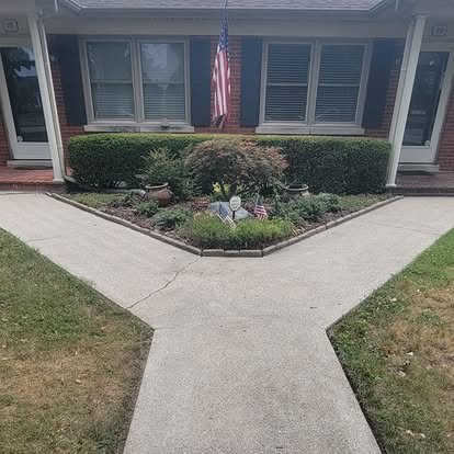 After: bright, clean concrete walkway in front of a brick home